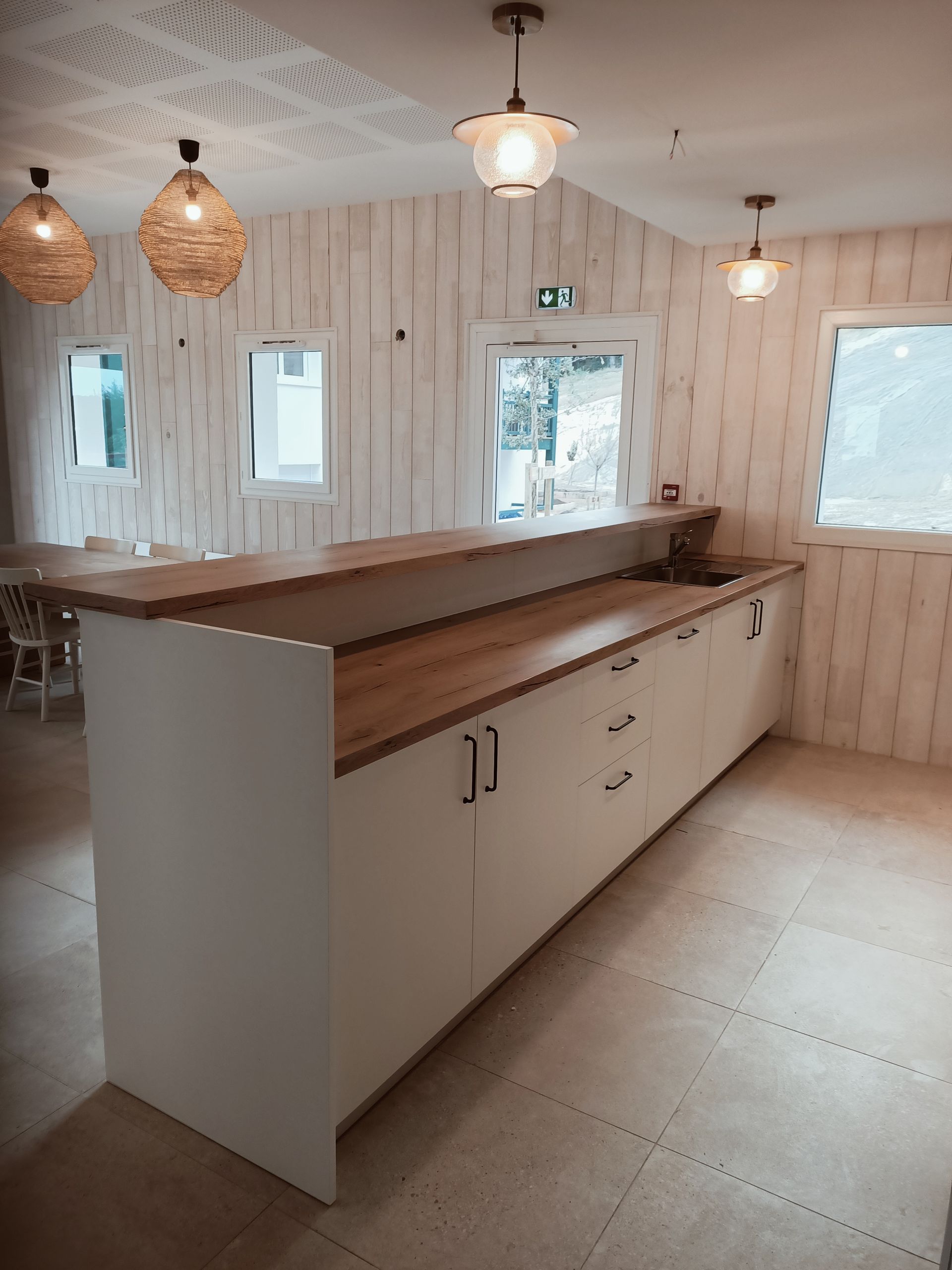 Un salon avec un canapé bleu et une porte donnant sur une cuisine.