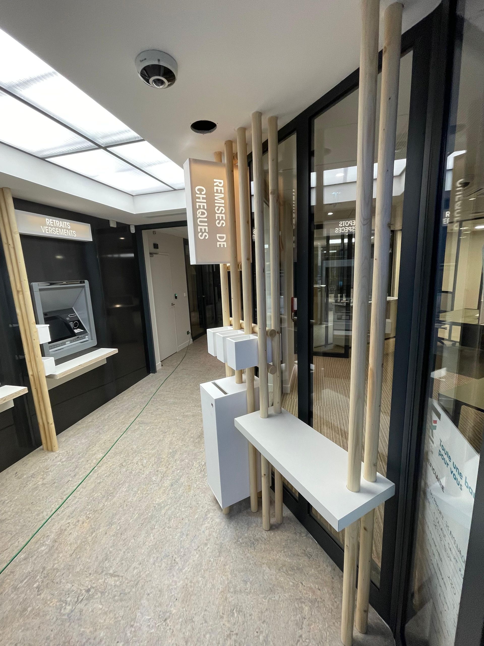 Intérieur d'une agence bancaire avec distributeur automatique de billets.