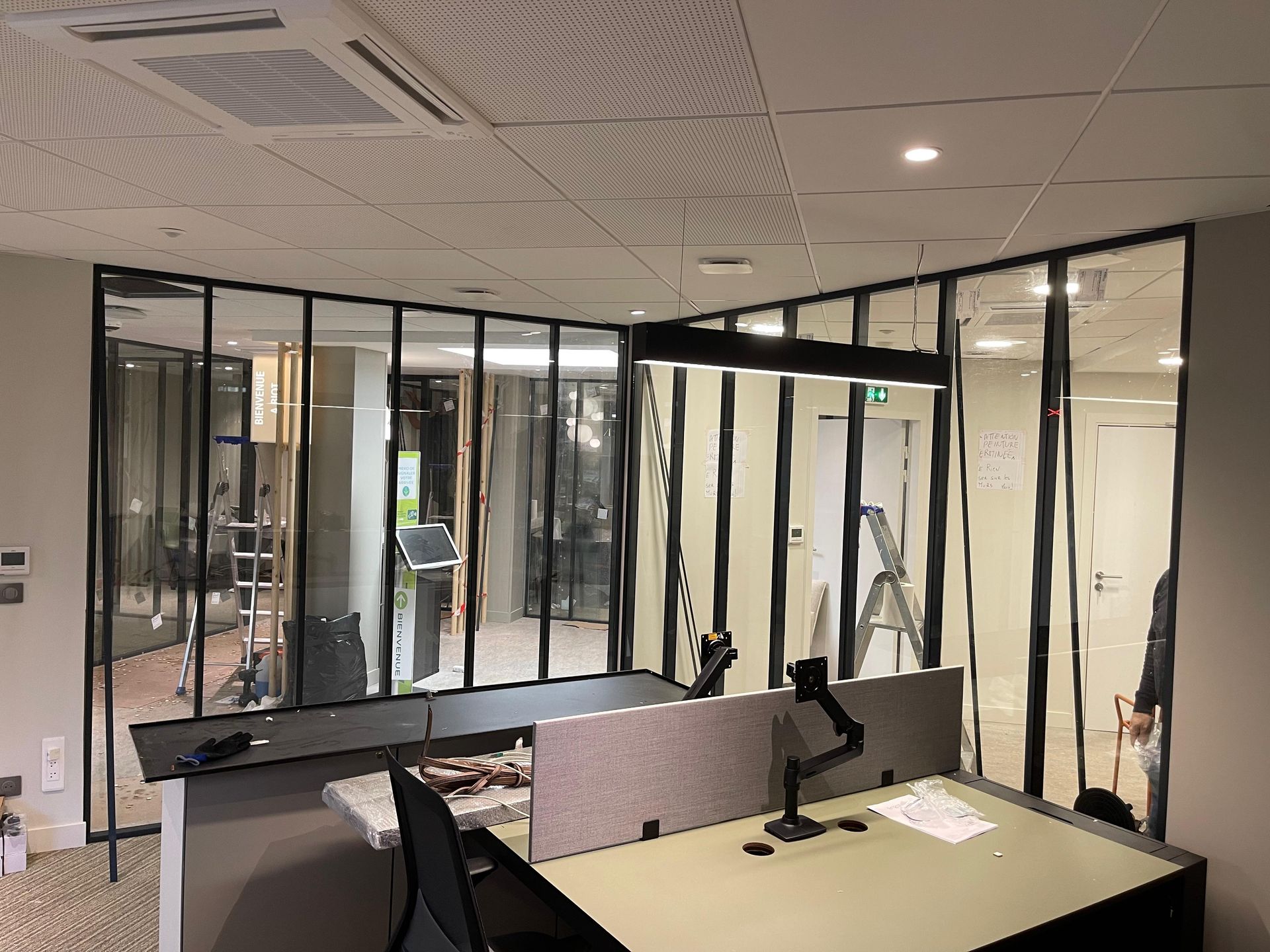 Un salon avec un canapé bleu et une porte donnant sur une cuisine.