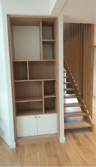 Un escalier en bois est à côté d'une étagère en bois