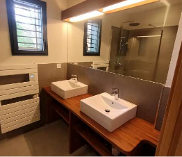 Une salle de bain avec deux lavabos et un miroir