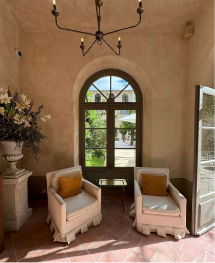 Une pièce avec deux chaises et un vase de fleurs