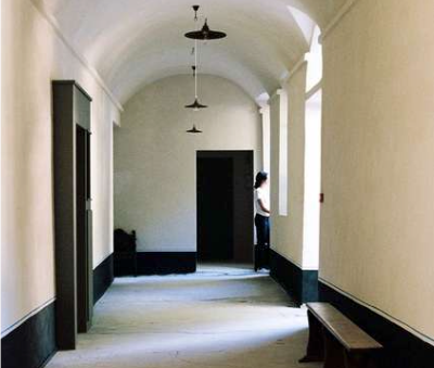 Un long couloir avec des plafonds voûtés et un banc