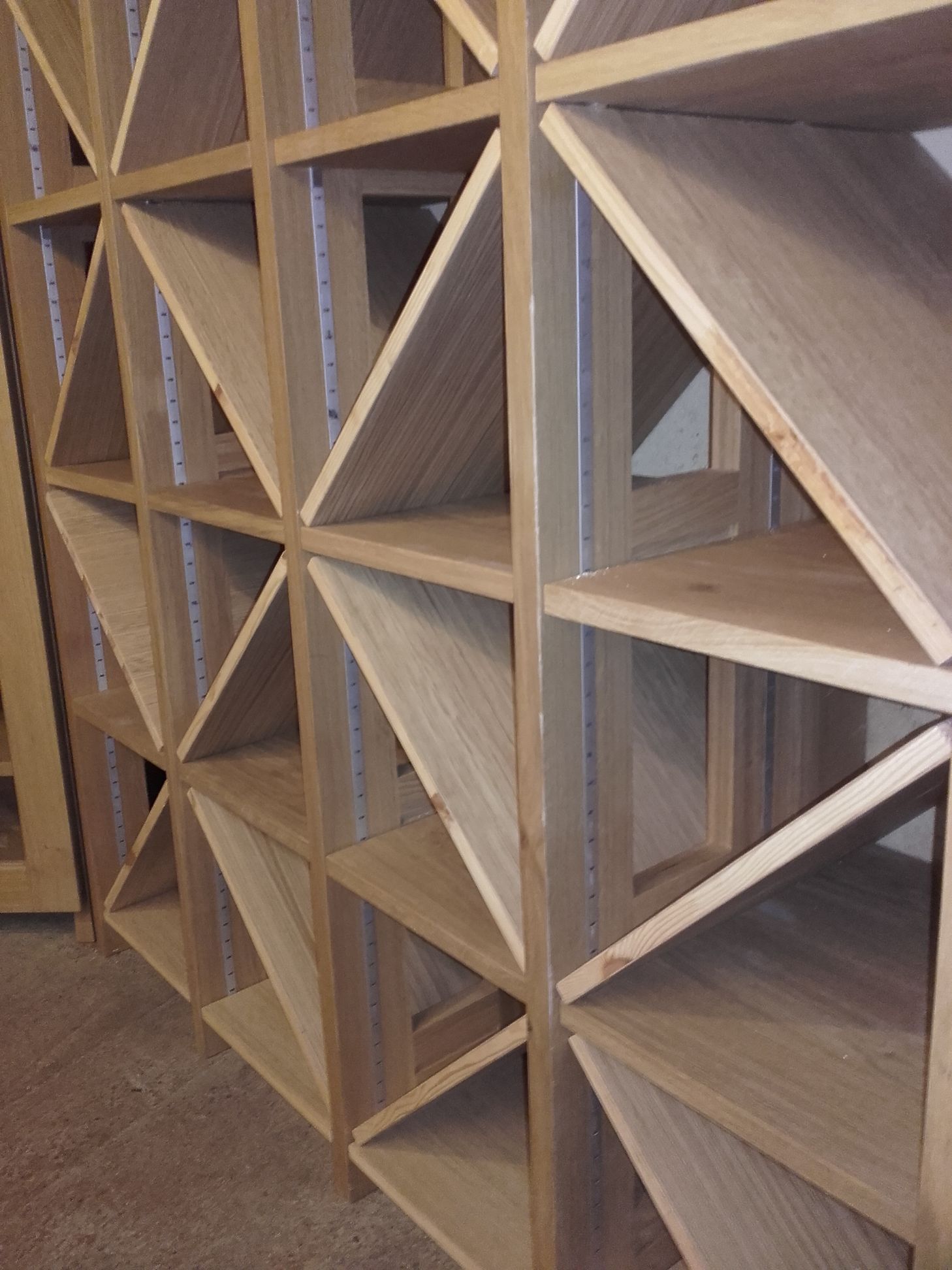 Une rangée d'étagères en bois avec des étagères en forme de triangle