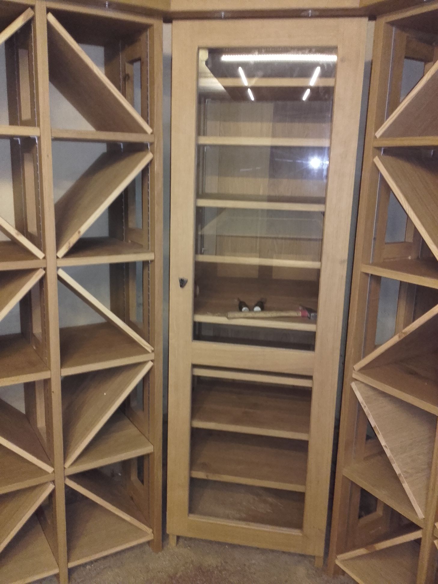 Un coin d'une pièce avec des étagères et une porte vitrée