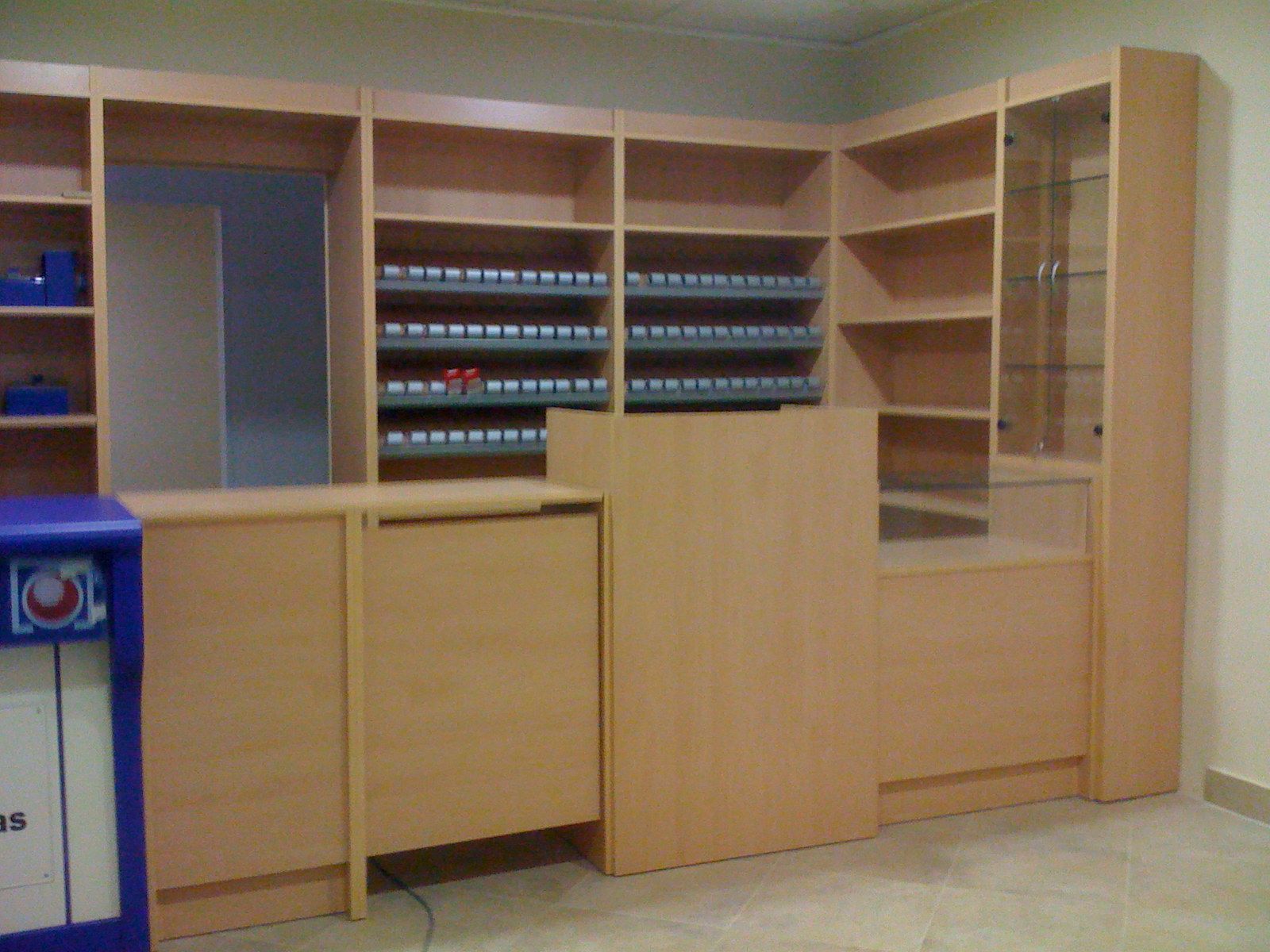 Estantería de madera para sala de correo de oficina con compartimentos, contenedores y un cubo de basura azul.
