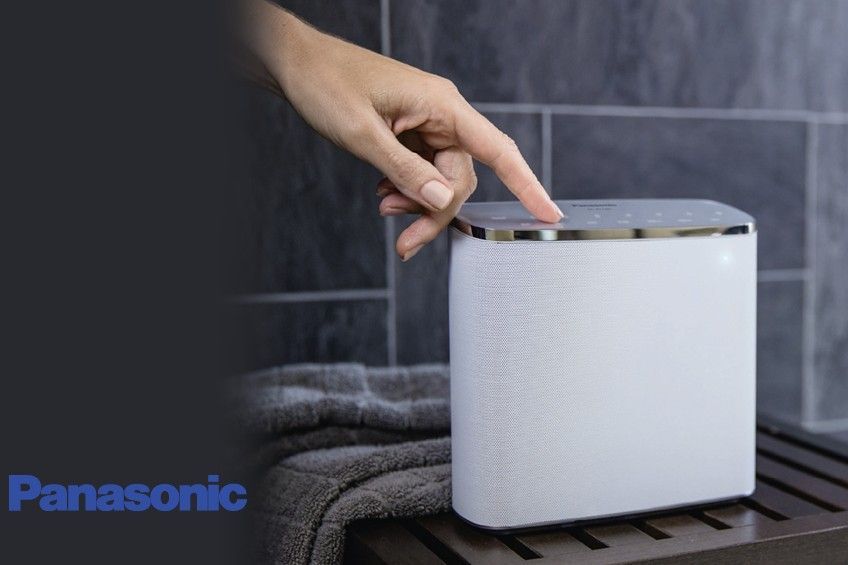 Eine Person drückt eine Taste auf einem Panasonic-Lautsprecher