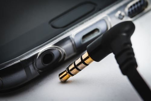 Fachberatung für TV Geräte Lindlar Eine Nahaufnahme eines 3,5-mm-Steckers, der in ein Mobiltelefon eingesteckt ist.