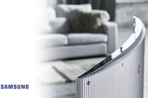 Ein Samsung-Fernseher steht in einem Wohnzimmer mit einer Couch im Hintergrund
