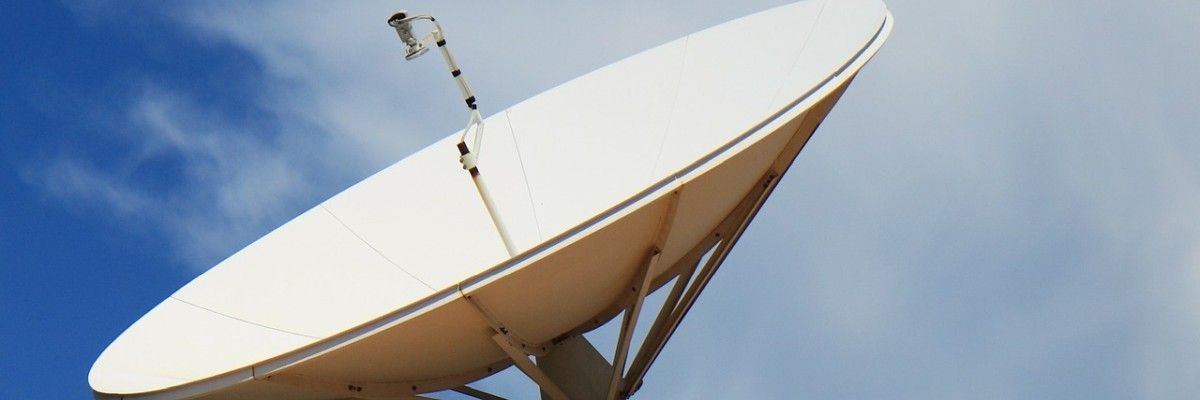 Eine große weiße Satellitenschüssel vor blauem Himmel