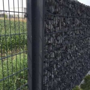 Eine Nahaufnahme eines Zauns aus Draht und Steinen.