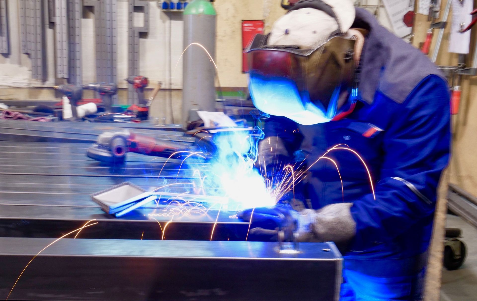 Ein Mann mit einer Schweißmaske schweißt ein Stück Metall.