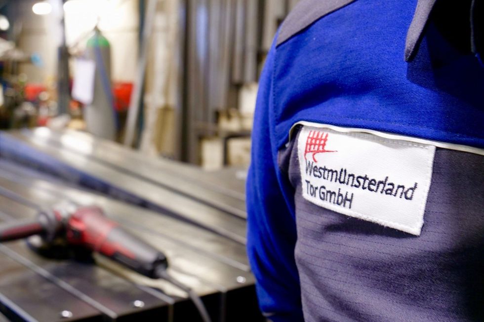 Eine Person, die eine blau-graue Uniform mit einem Etikett auf dem Rücken trägt, auf dem „Westminsterland“ steht
