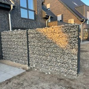 Ein Backsteingebäude mit einem Steinzaun davor