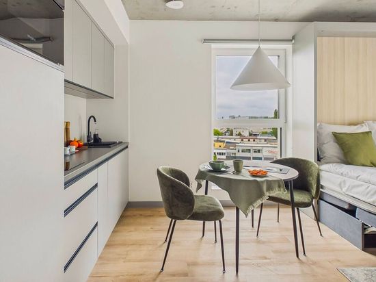 Mały, nowoczesny apartament z kuchnią, stołem jadalnym, oknem i łóżkiem w jasnym, minimalistycznym pokoju
