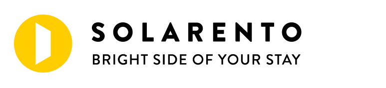 Logo Solarento z żółtą okrągłą ikoną i czarnym tekstem, slogan „Jasna strona Twojego pobytu”