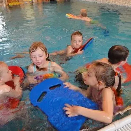 Kinder spielen mit bunten Schwimmreifen in einem Schwimmbecken