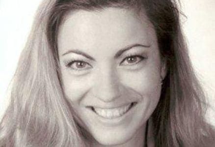 Lächelnde Frau mit langen Haaren in einem Schwarz-Weiß-Porträt