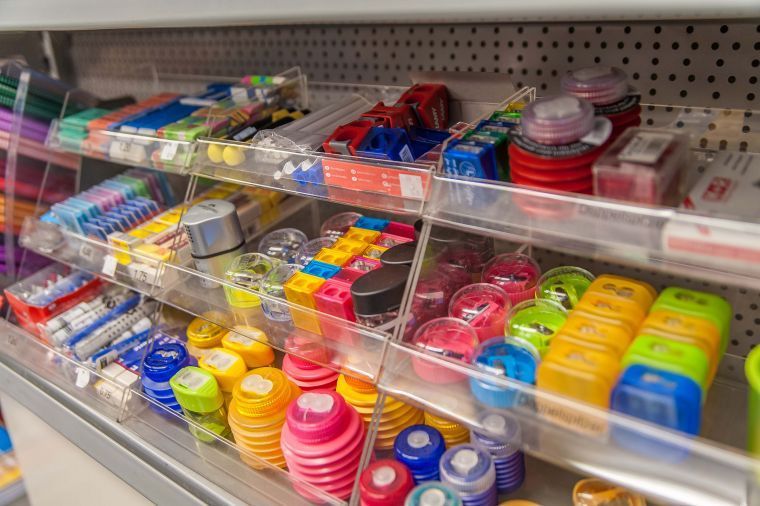 Verschiedene bunte Pillenboxen und kleine Behälter sind in den Regalen des Ladens aufgereiht.