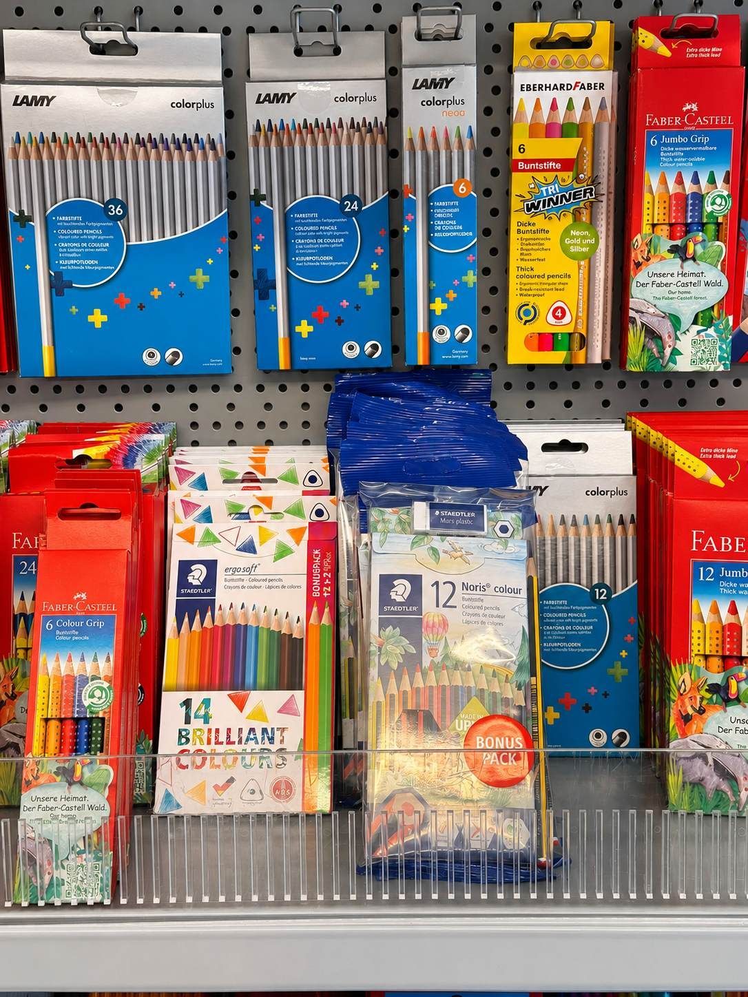 Verschiedene farbige Geschenkboxen und Schreibwarenartikel sind in einem Ladenregal ausgestellt.