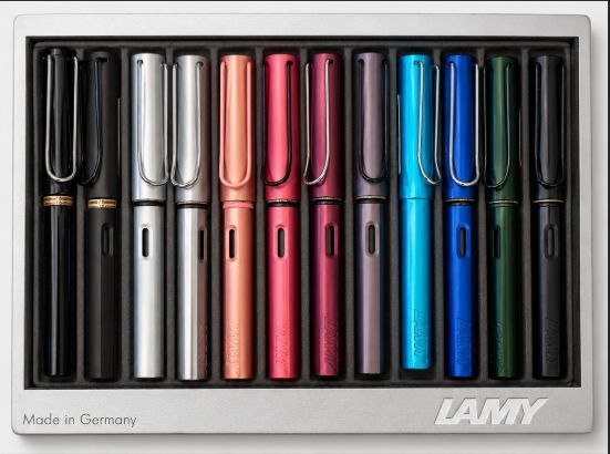 Verschiedene bunte LAMY-Füllfederhalter in einer Schachtel, von Schwarz und Silber bis Rosa und Blau.