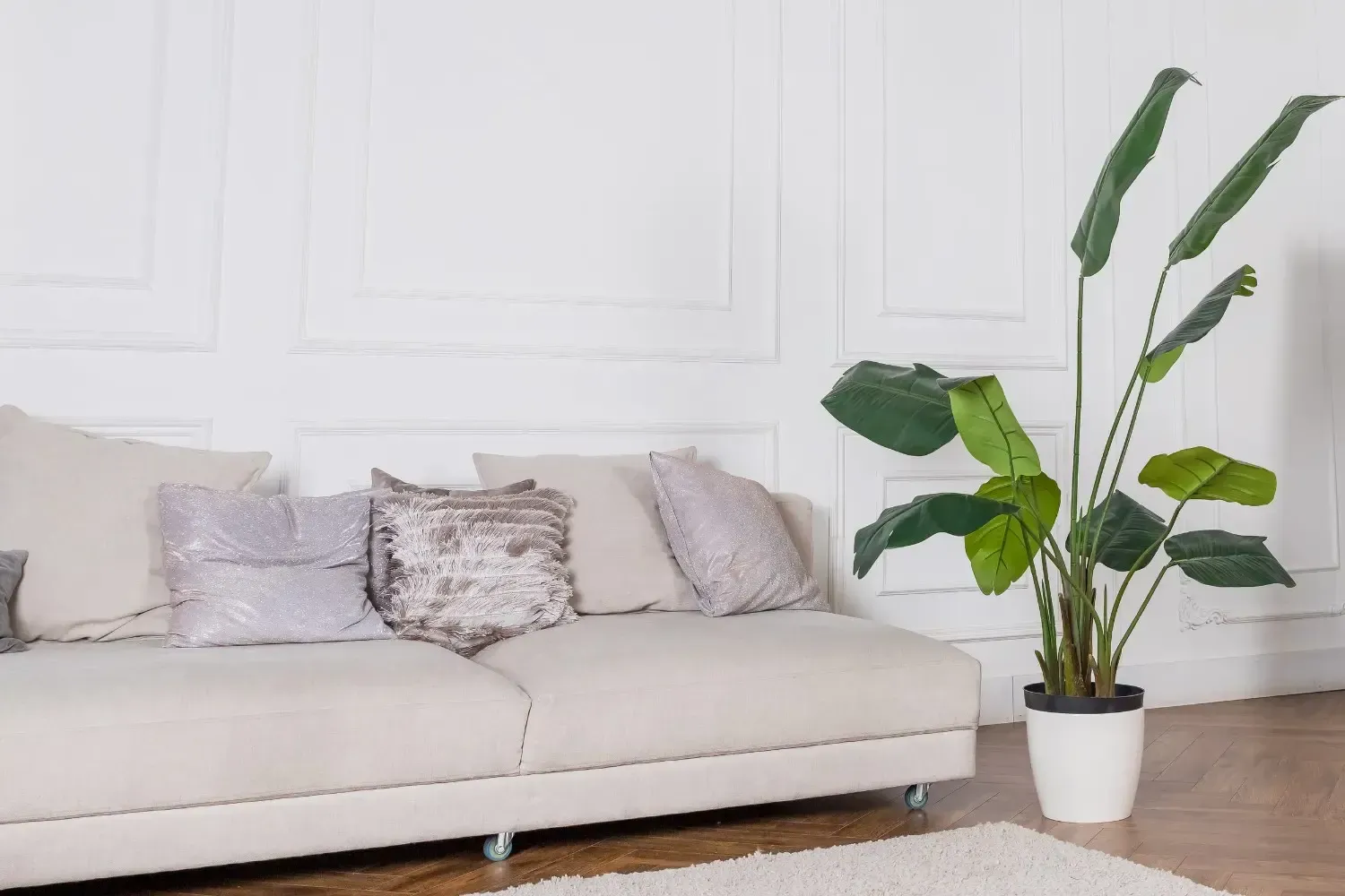 Un sofá beige con cojines decorativos se encuentra en una habitación luminosa.