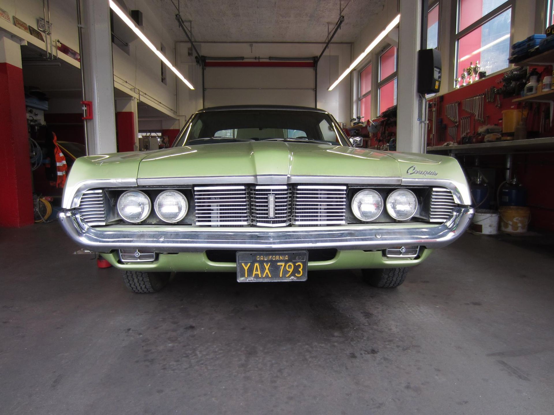 Weißer Oldtimer in einer Garage, Vorderansicht.