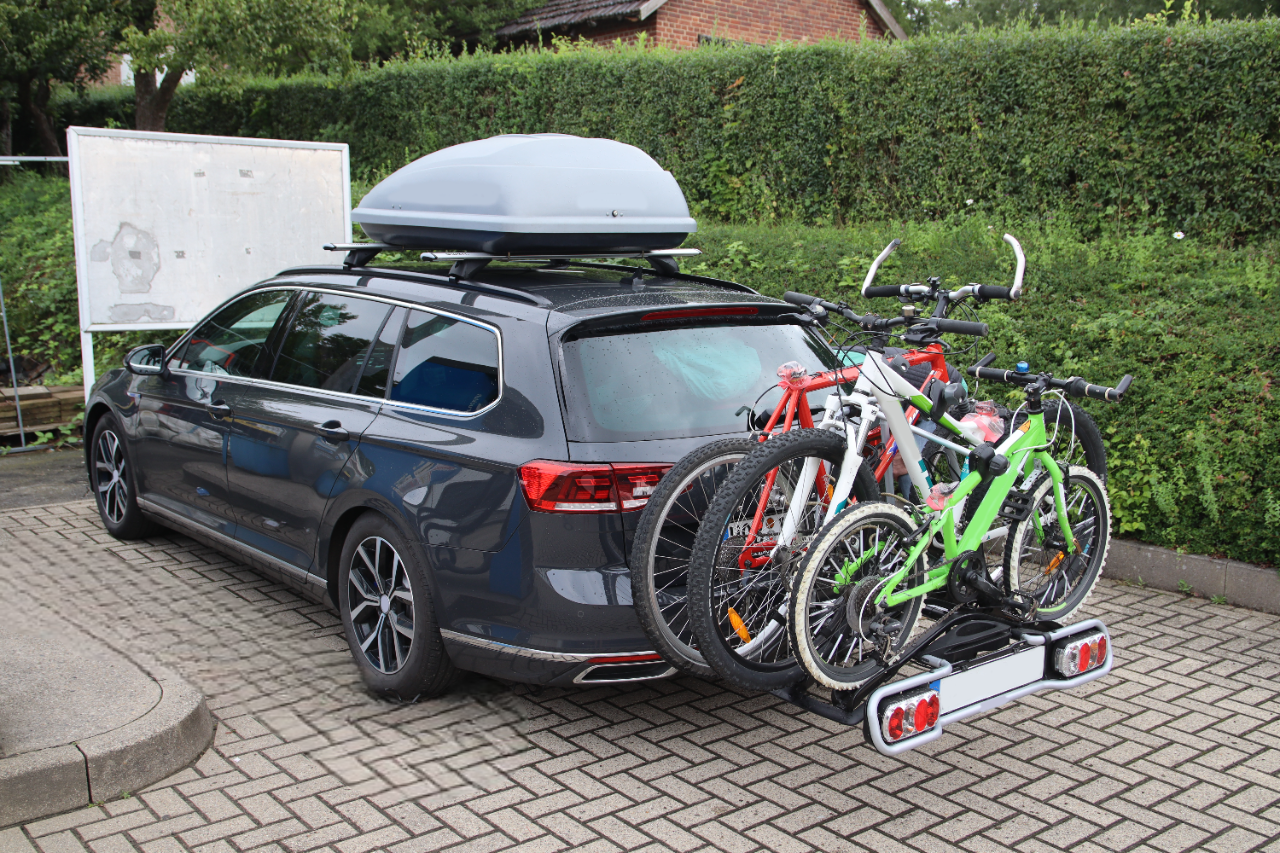 Blau-weißer klassischer Sportwagen mit geöffneter Motorhaube in einer Garage.