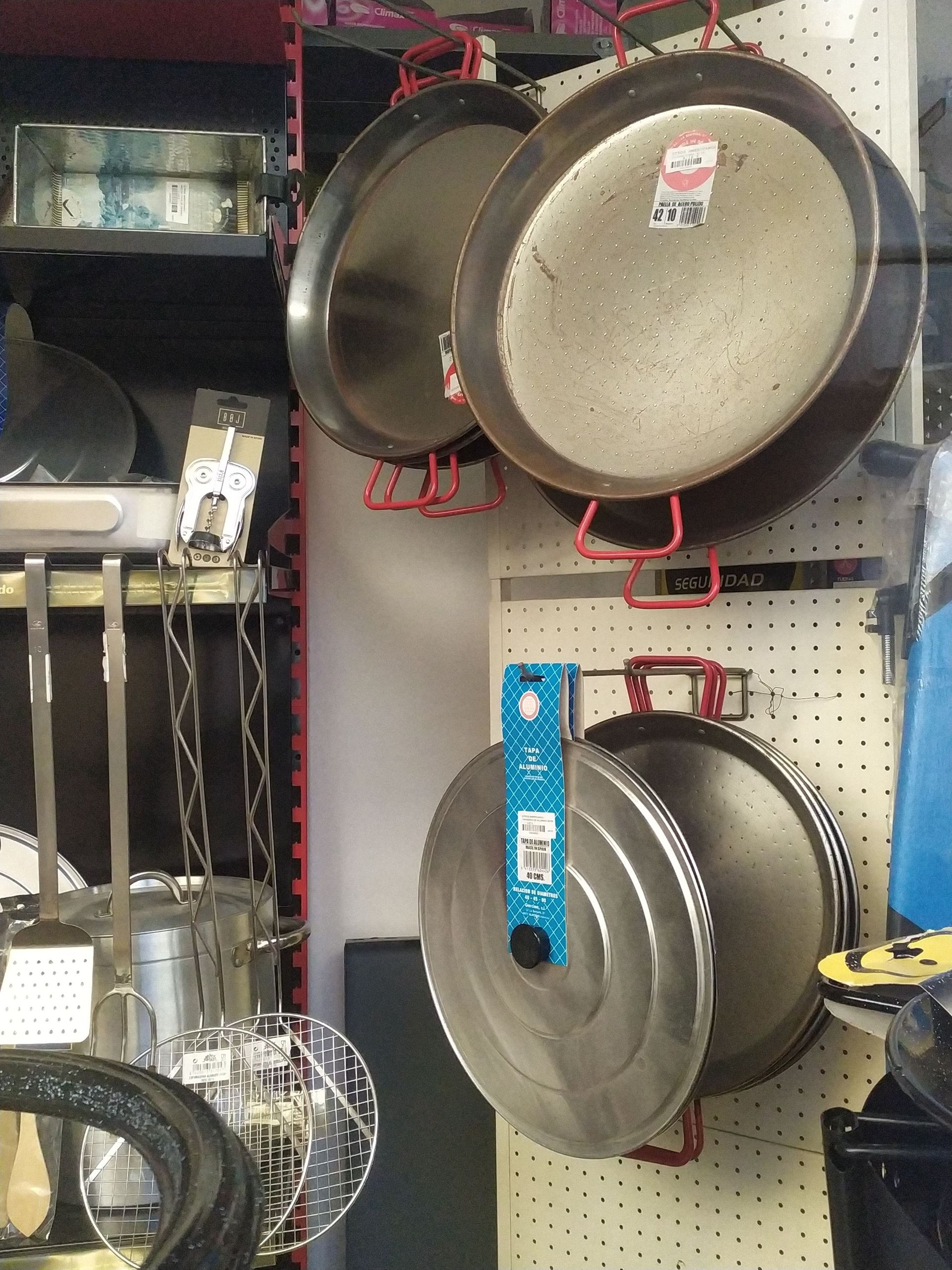 Un montón de ollas y sartenes colgadas en una pared