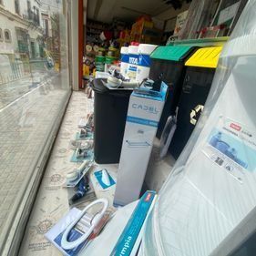 Un montón de cajas están en el suelo delante de una ventana de una tienda.