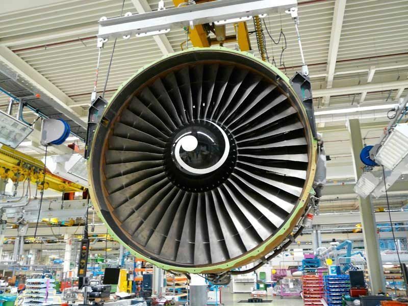 Un gran motor de avión cuelga del techo de una fábrica.