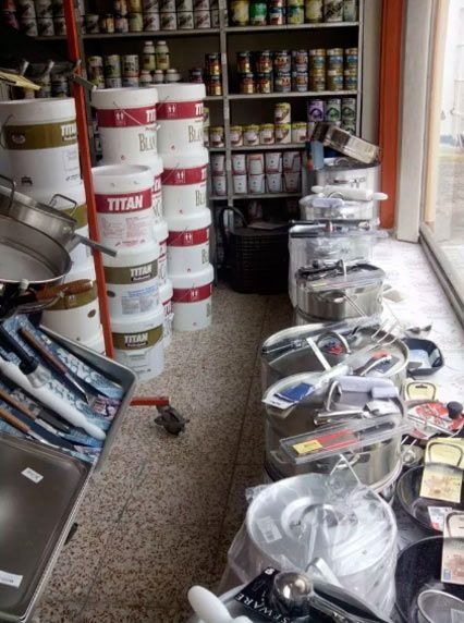 Una tienda llena de cubos de pintura Titan y ollas y sartenes.