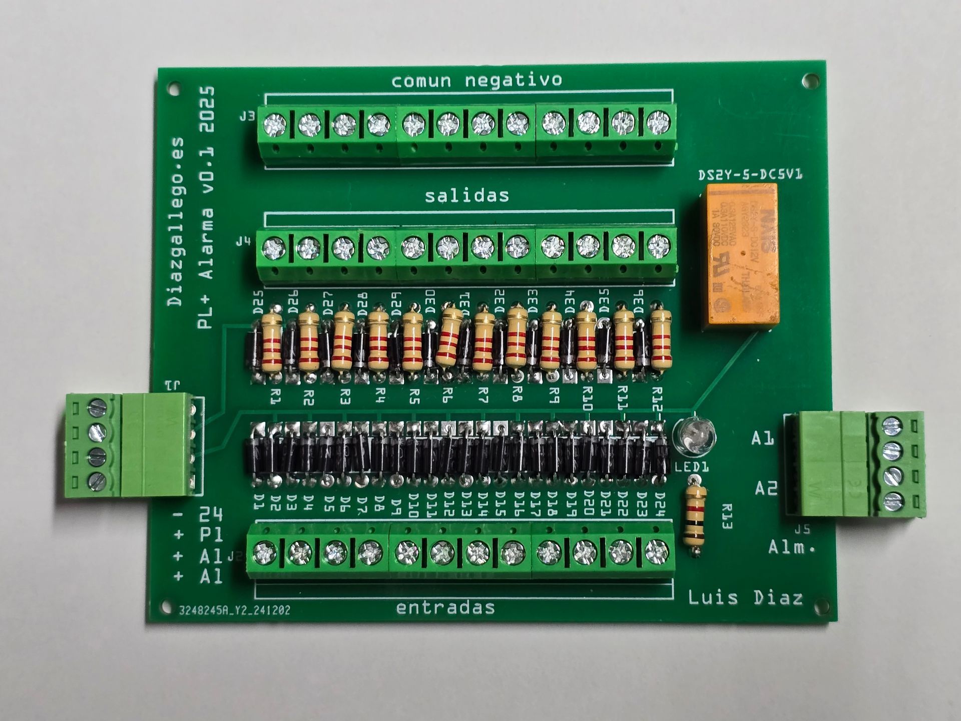 Placa de prototipado electrónico con componentes, cables y un relé AXICOM etiquetado sobre una base perforada