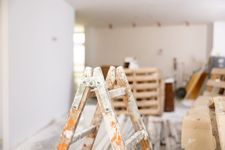 Caballetes de madera polvorientos y pilas de palés en una habitación luminosa.