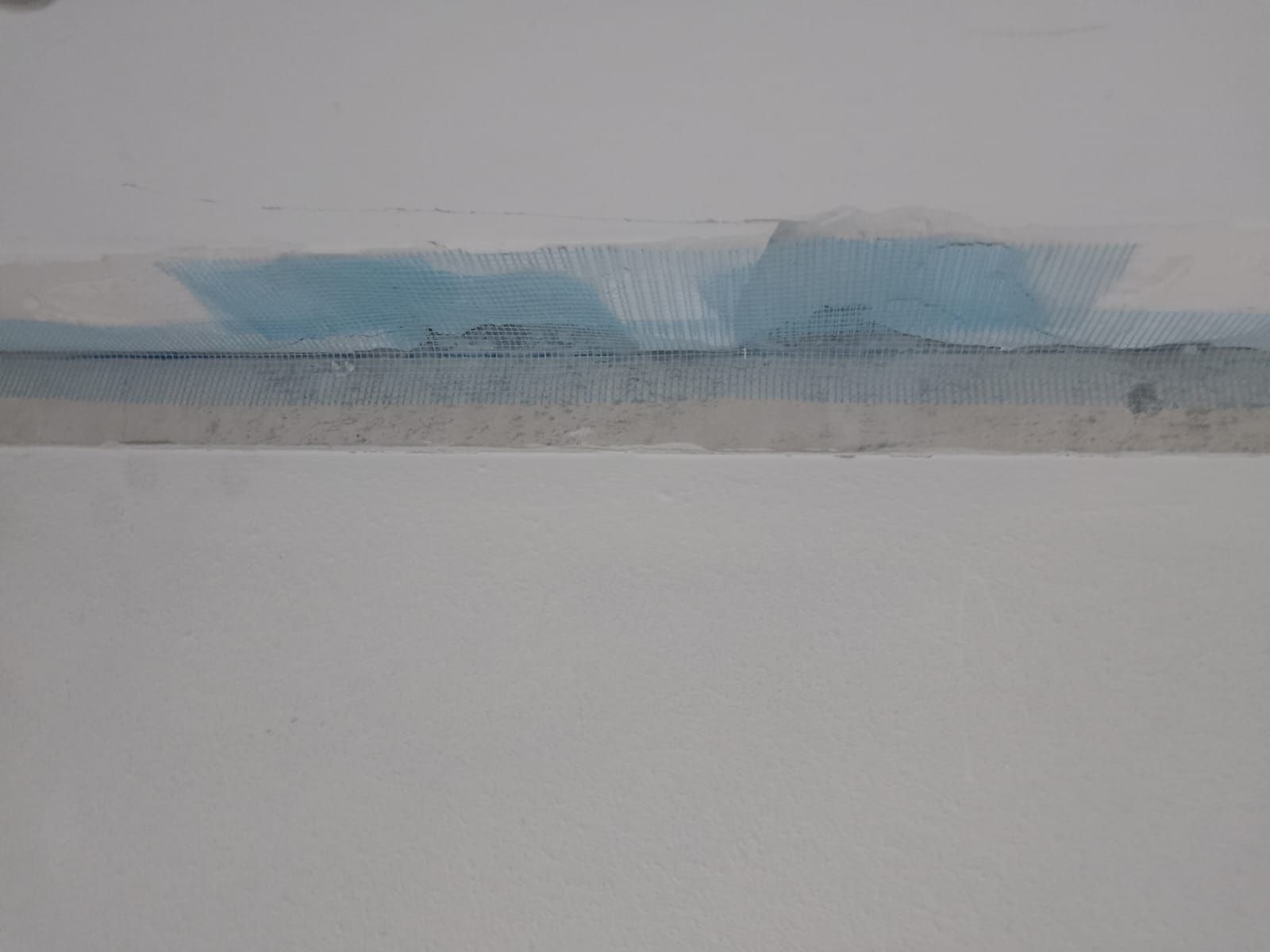 Franja abstracta de acuarela azul y gris en la parte superior de una página mayormente blanca.
