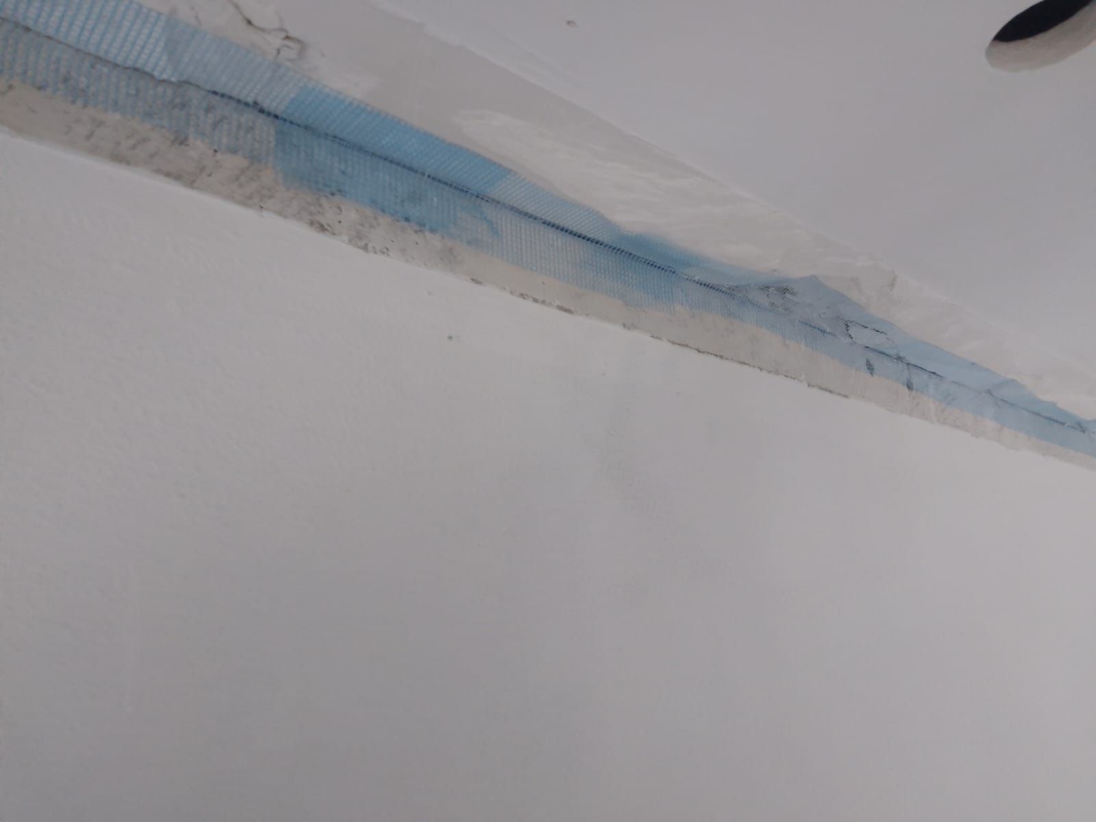 Esquina del techo con una larga mancha de agua azul a lo largo del borde de la pared.