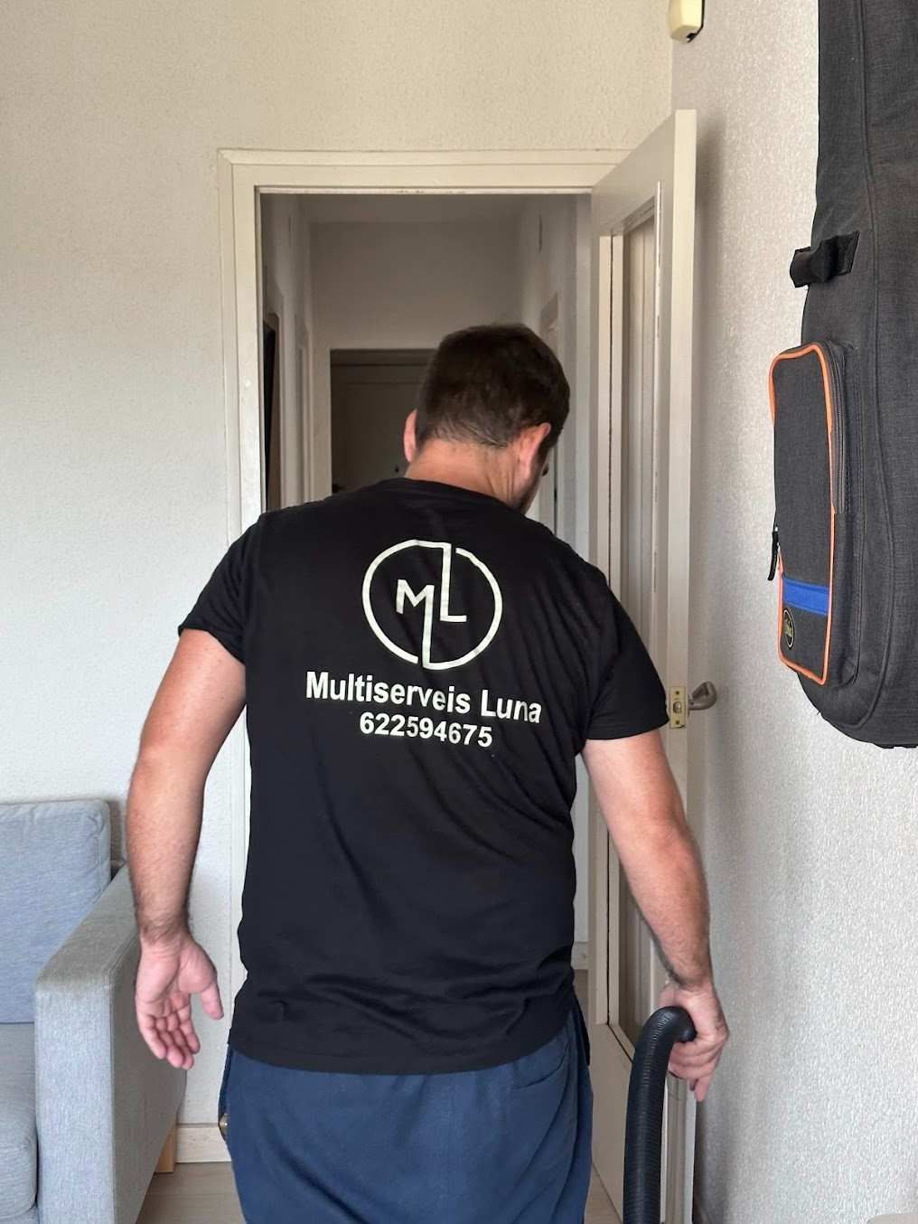 Hombre con camisa negra con el logo