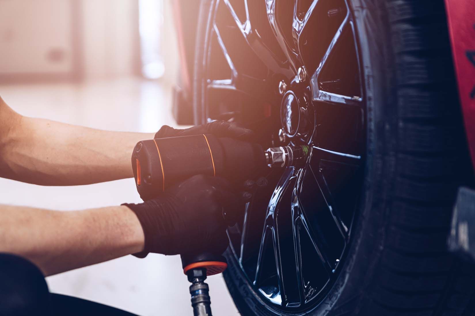 Professionnel vissant une roue de voiture