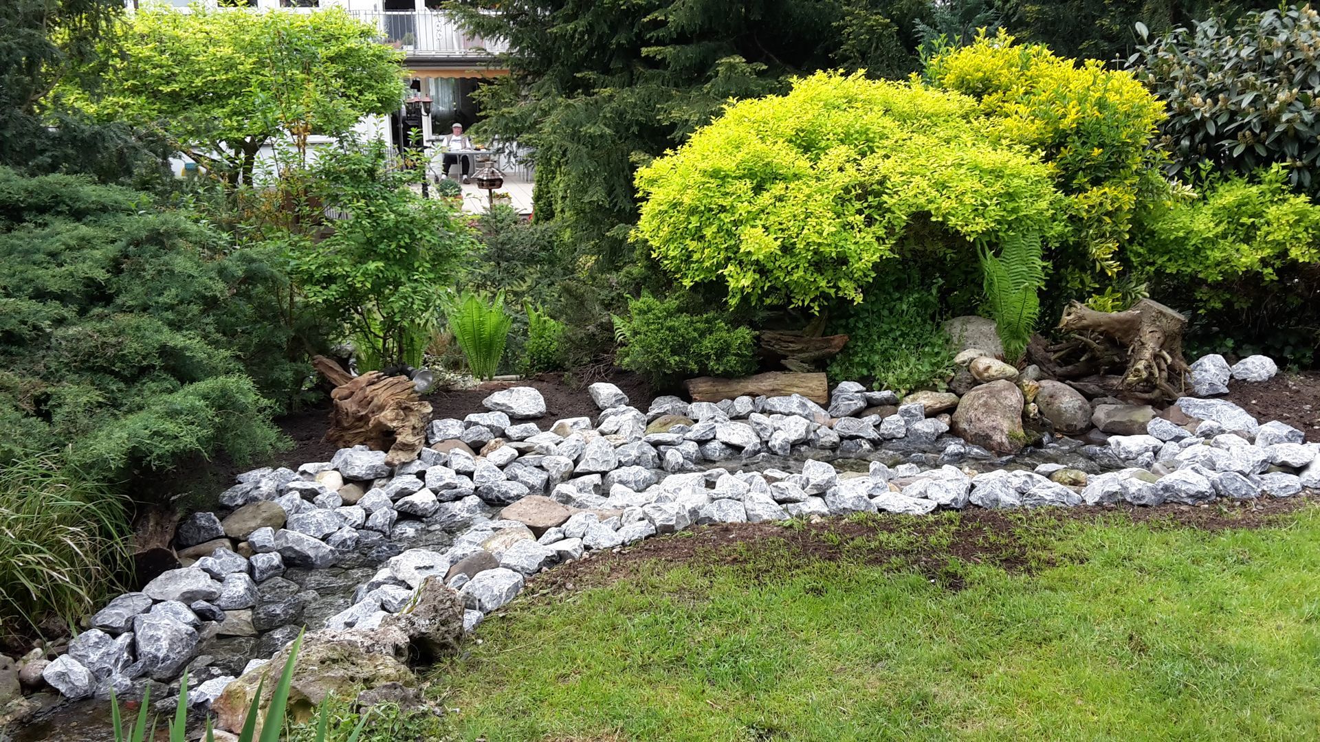 Volker Hahn Garten- und Landschaftsbau, Grünanlage mit runder Steinmauer