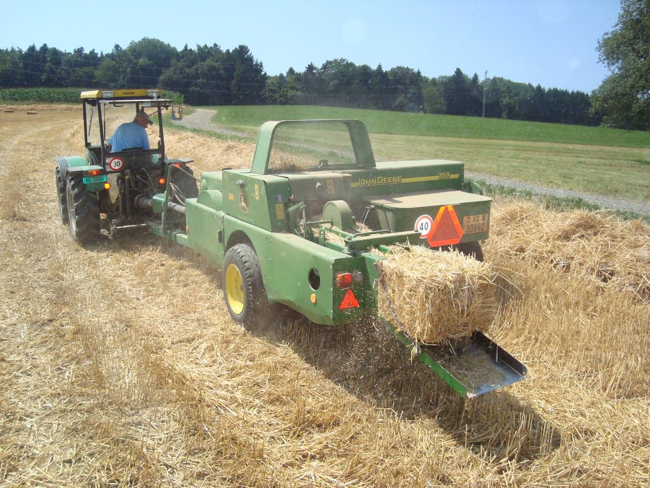 Vogler Lohnunternehmung – Traktor sammelt Heu von einem Feld