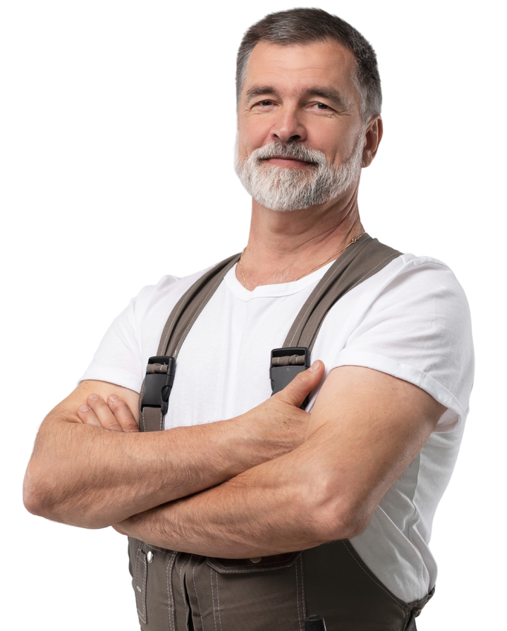 Homme à la barbe grise, bras croisés, vêtu d'une salopette et d'un t-shirt blanc. Il sourit avec assurance.