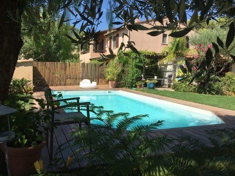 Piscine en polyester au centre d'un jardin fourni