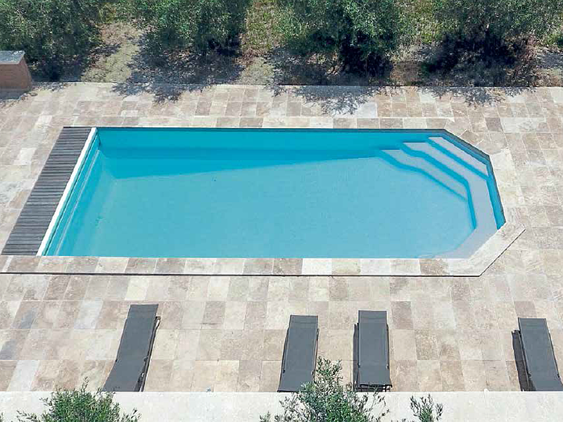Grande piscine en polyester avec des transats gris
