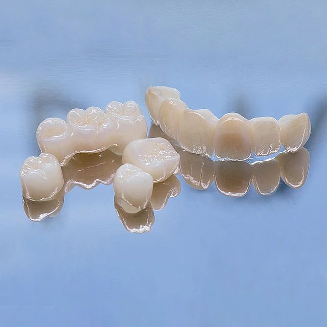 Un primer plano de un juego de coronas dentales sobre una superficie azul.