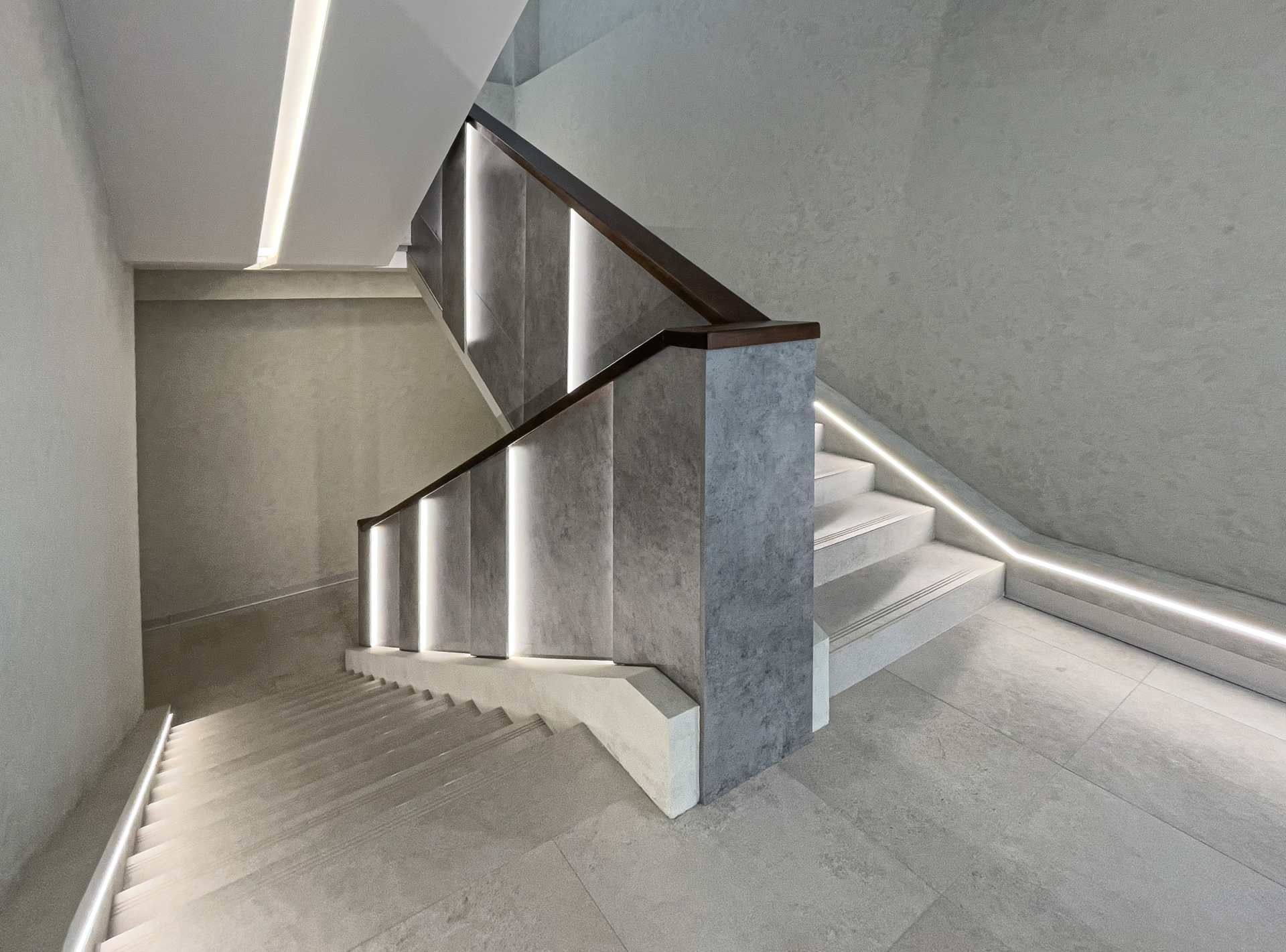 Eine Treppe mit Holzgeländer und Lichtern auf den Stufen