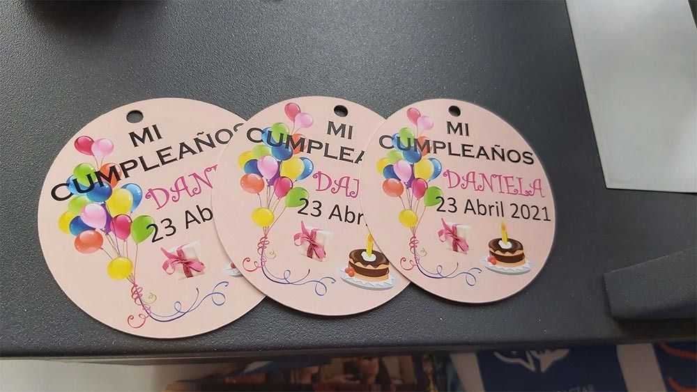 Tres etiquetas de cumpleaños con globos y un pastel.
