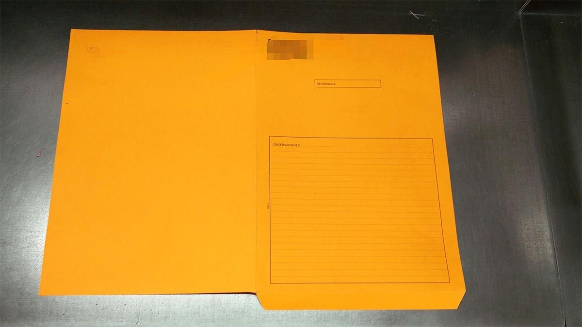 Una carpeta naranja con un trozo de papel dentro