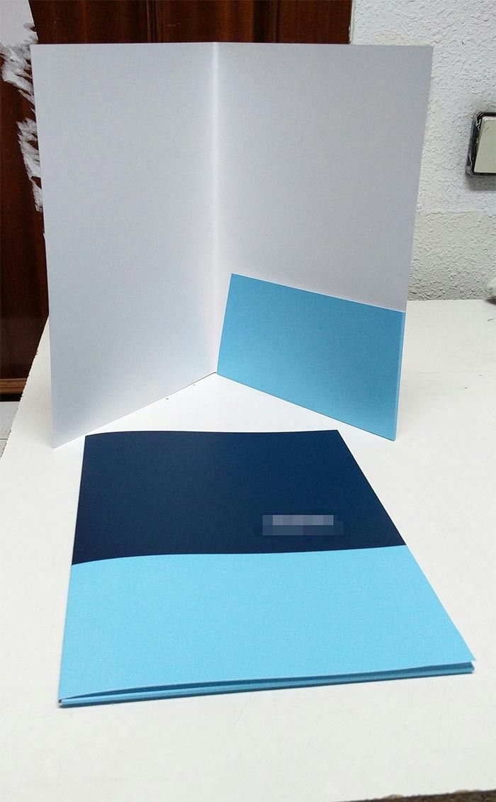 Una carpeta azul y blanca está abierta sobre una mesa