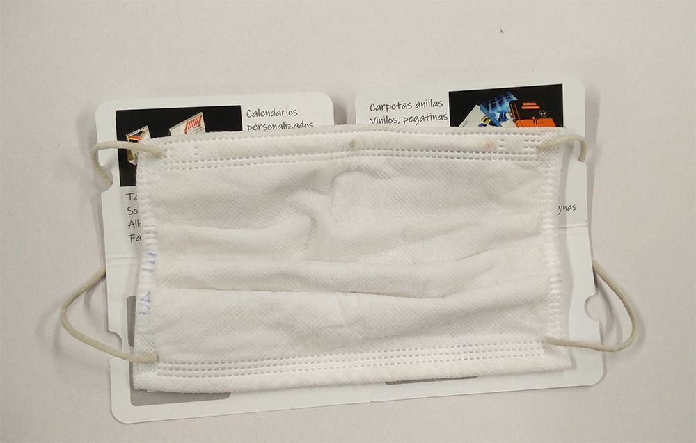Una máscara blanca está colocada encima de un trozo de papel.