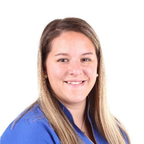 Una mujer con una camisa azul sonríe a la cámara.